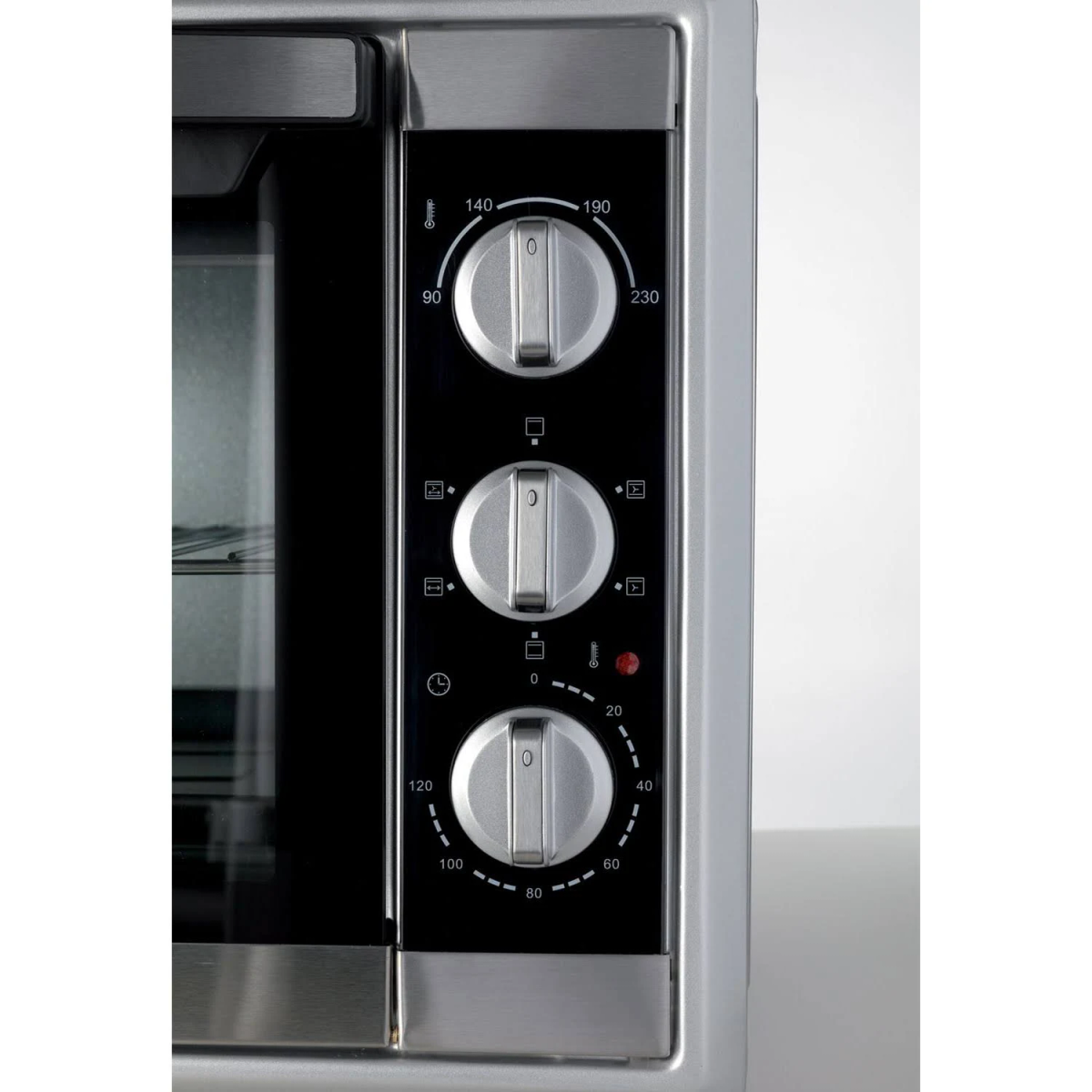 Primer plano del panel de control del horno con perillas y marcas de temperatura.
