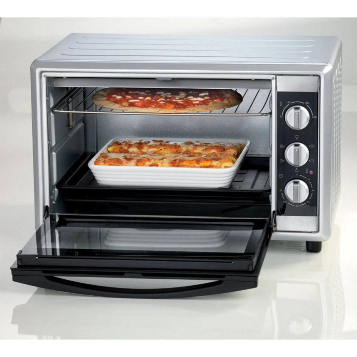 Horno tostador plateado con pizza y cazuela dentro, puerta abierta.