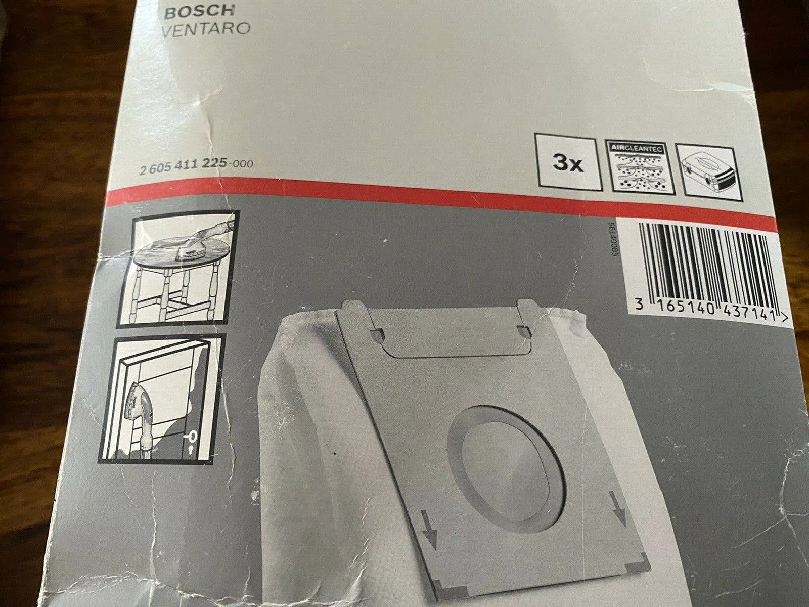 Un sacco per aspirapolvere in una scatola. Testo e diagrammi sulla scatola spiegano la funzione e l'uso del sacco.