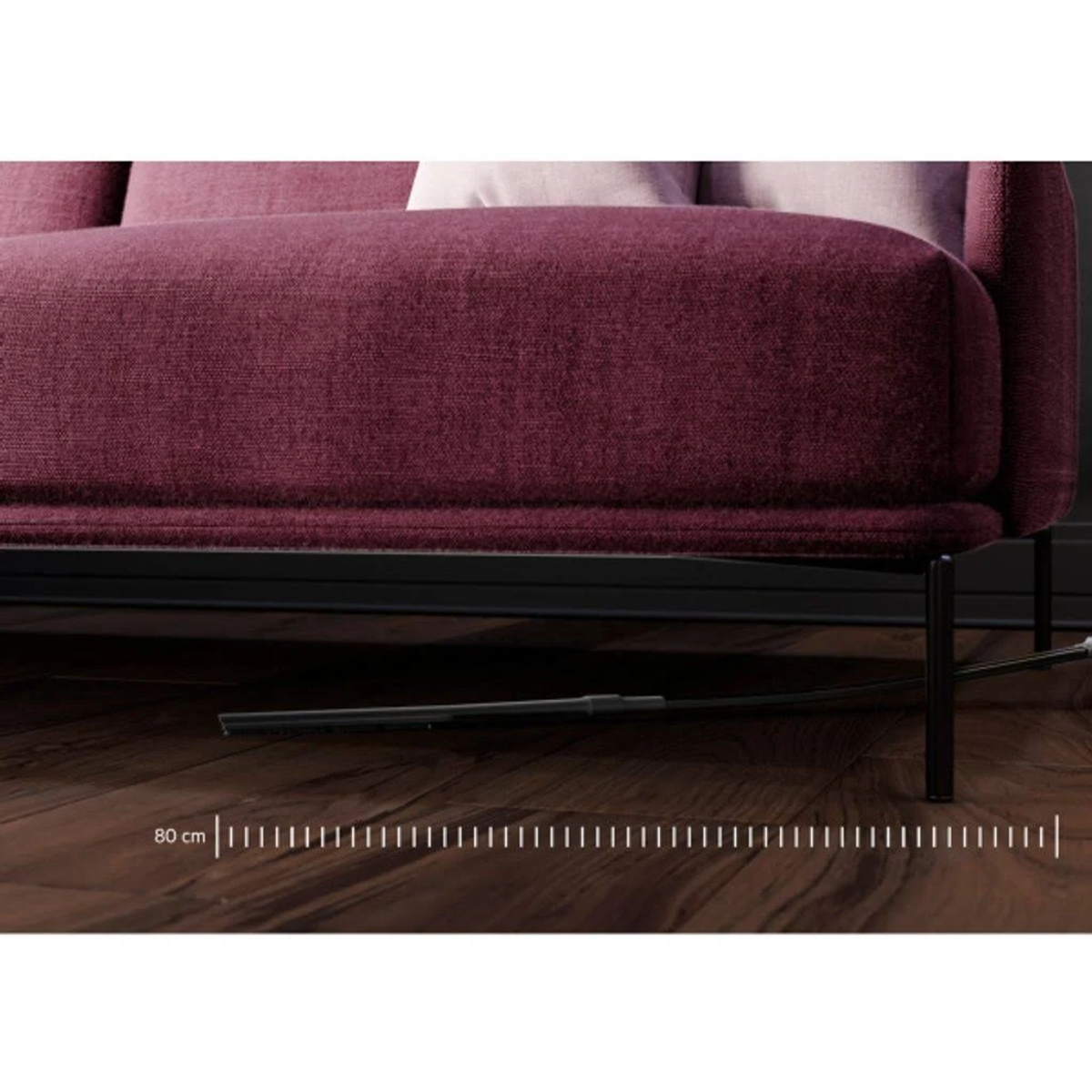 Bordowa sofa z czarnymi nogami. Na podłodze umieszczono linijkę o długości 80 cm.