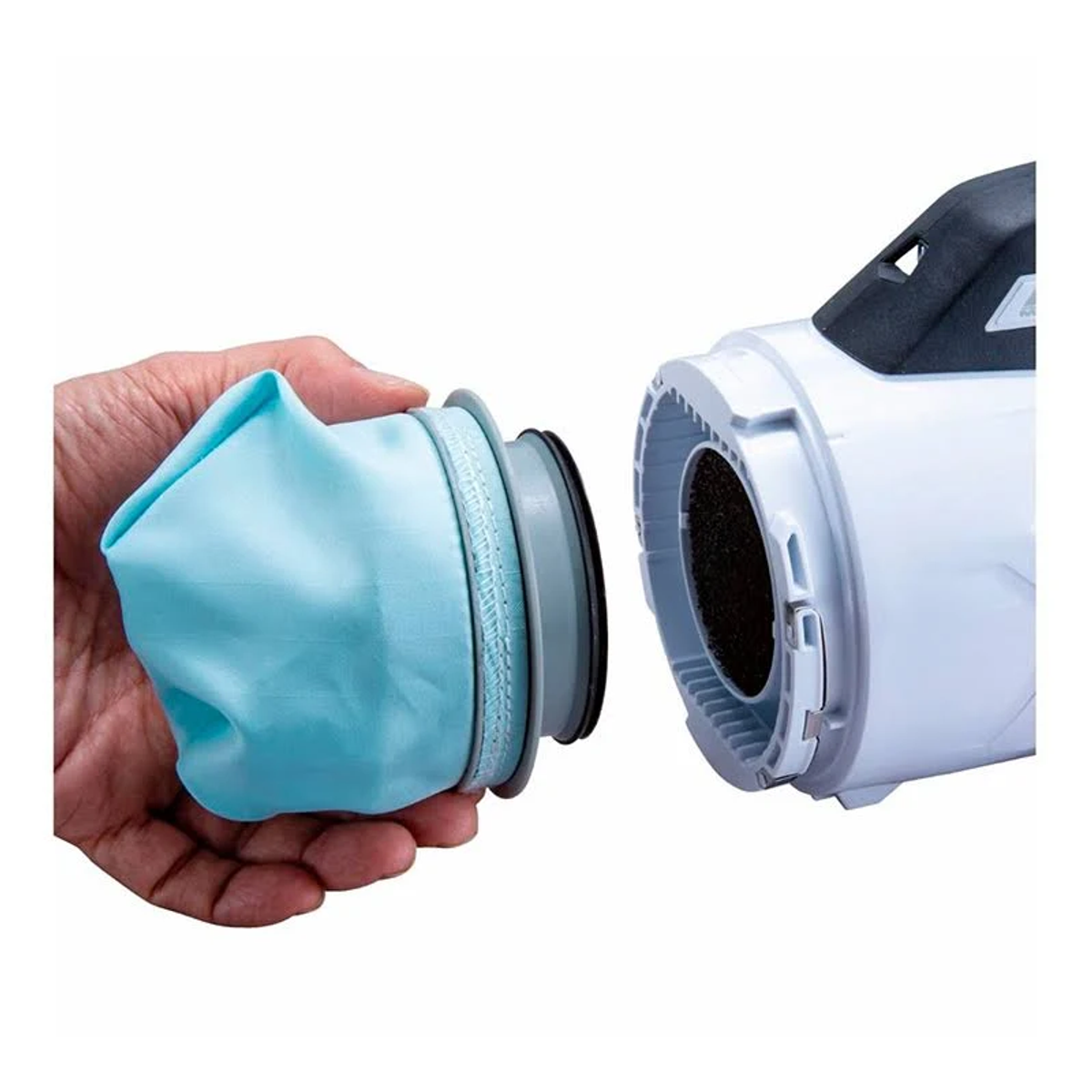 Mano sosteniendo una bolsa azul de aspiradora, junto a la aspiradora. Blanco.
