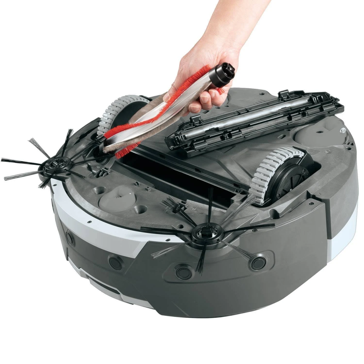 Mano che rimuove una spazzola da un robot aspirapolvere grigio, con ruote e spazzole laterali visibili.