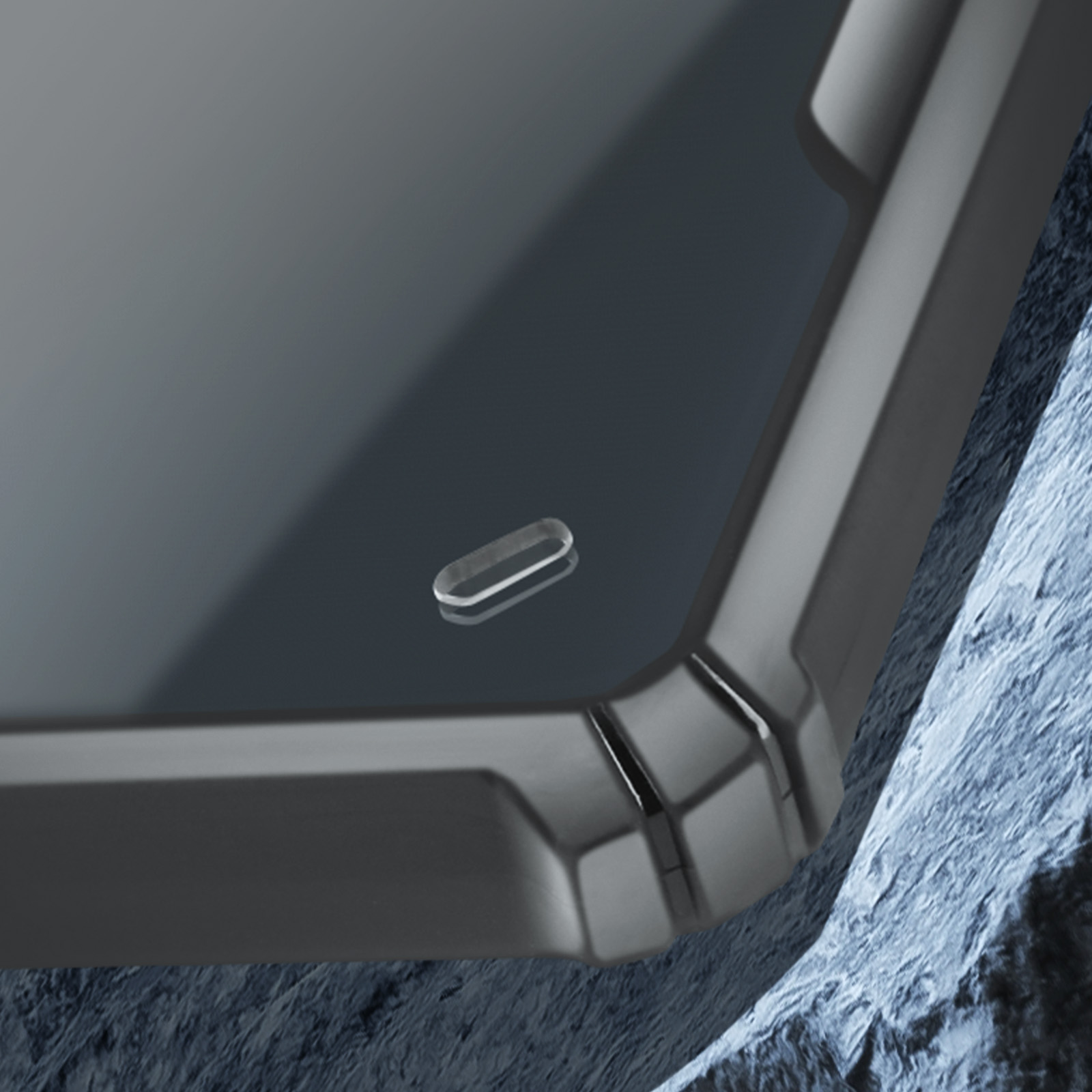 Primo piano di un telefono nero con un piccolo elemento di design trasparente a forma ovale.