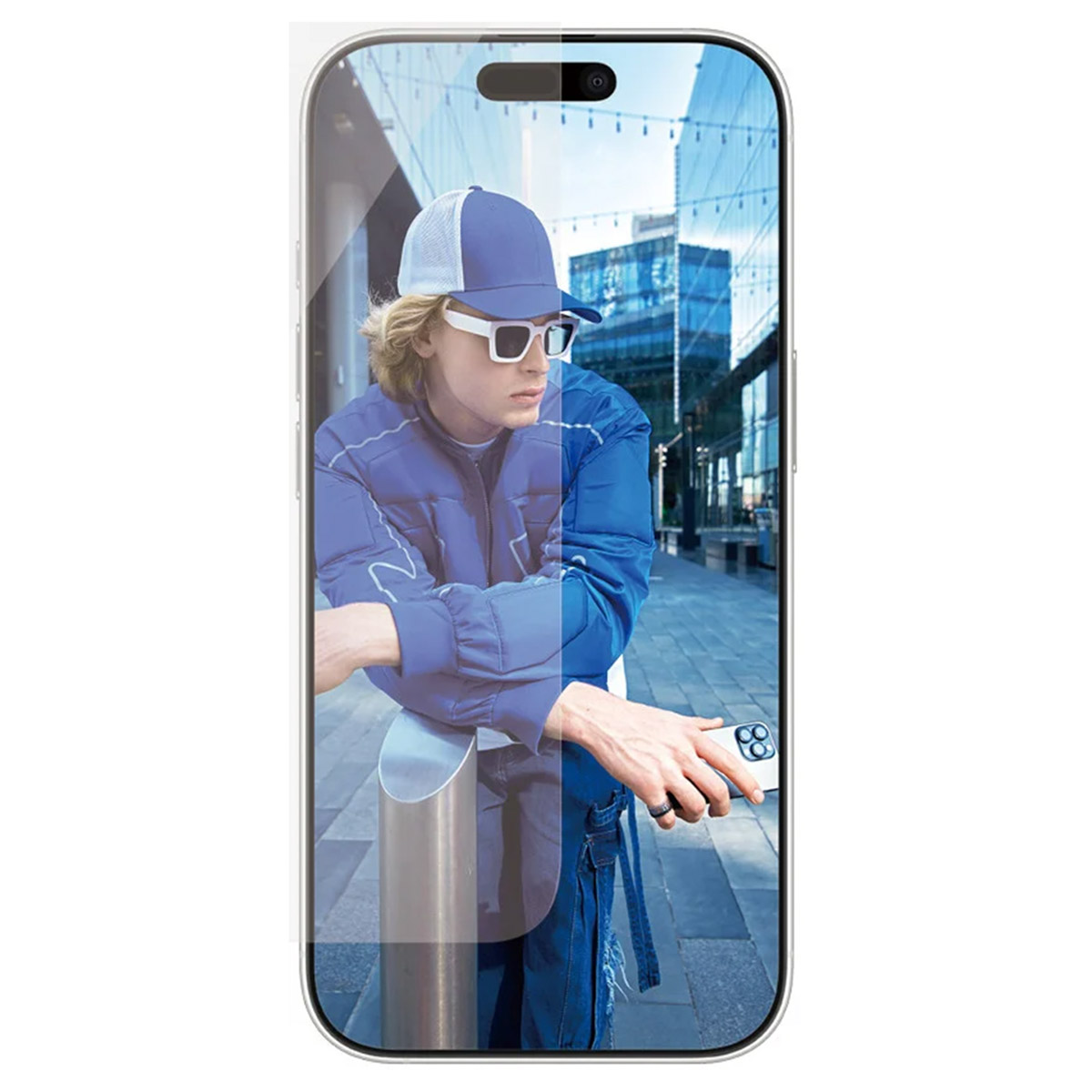 Uomo con occhiali da sole e abito blu si appoggia a una barra di metallo, guardando un telefono.