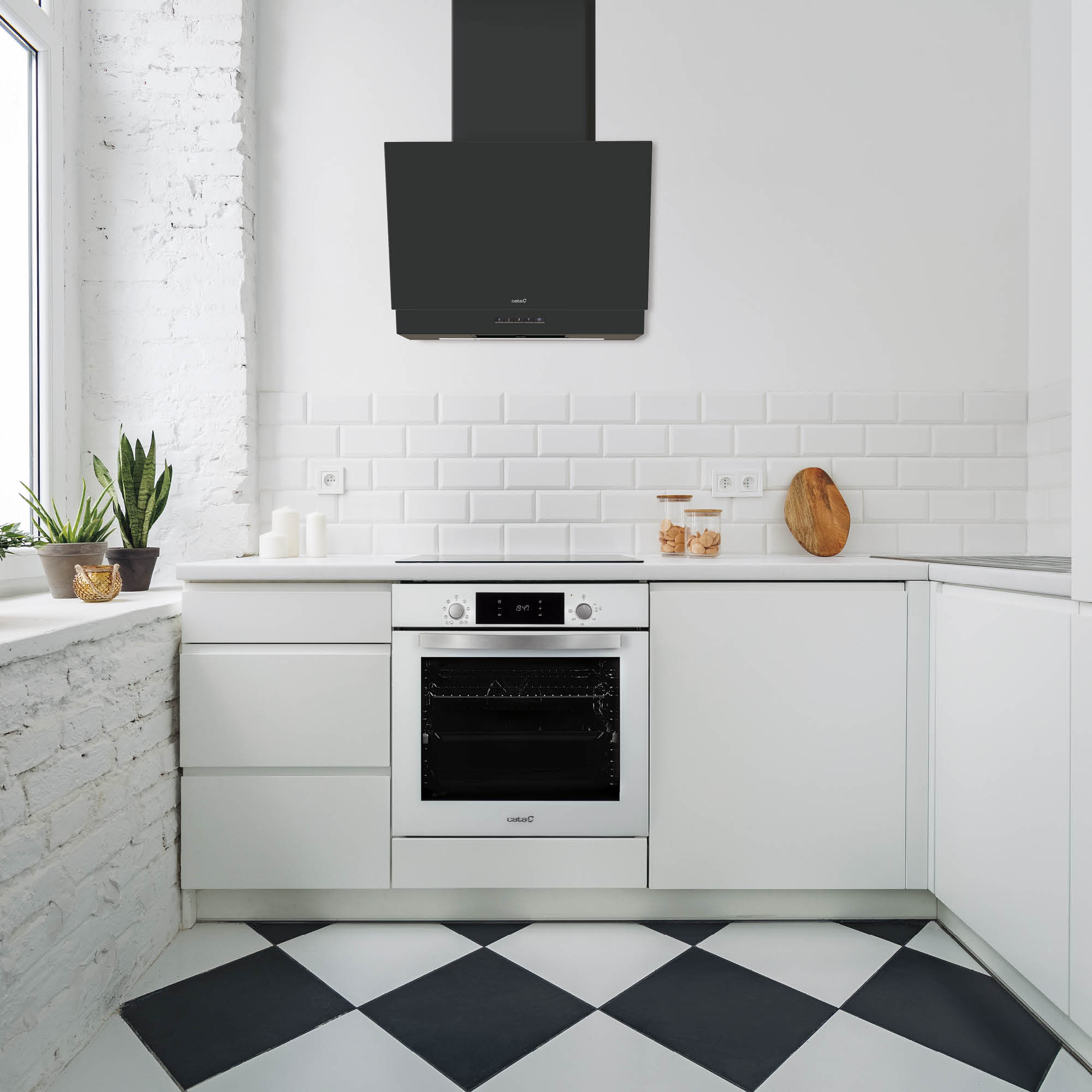 Una cucina bianca con una cappa nera e un pavimento a scacchiera.