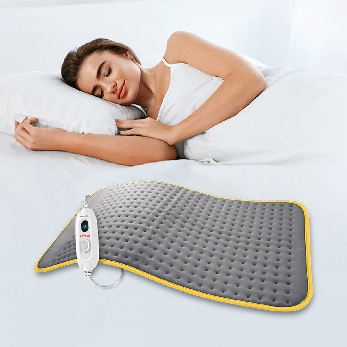 Kobieta śpiąca w łóżku z poduszką grzewczą. Szara poduszka z panelem sterowania.