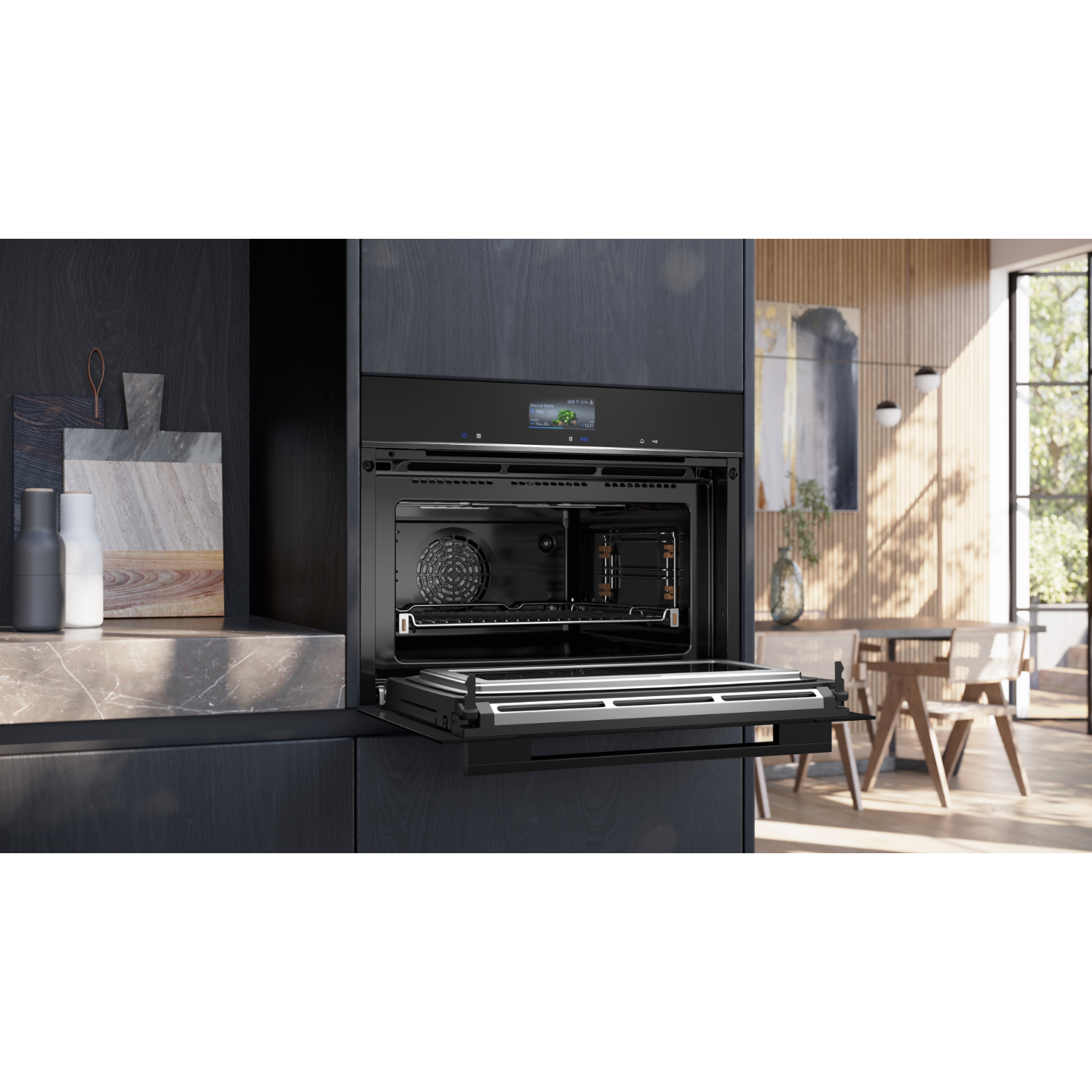 Zwarte oven met open deur die het interieur laat zien, in een donkere keuken. Houten tafel en stoel staan op de achtergrond.