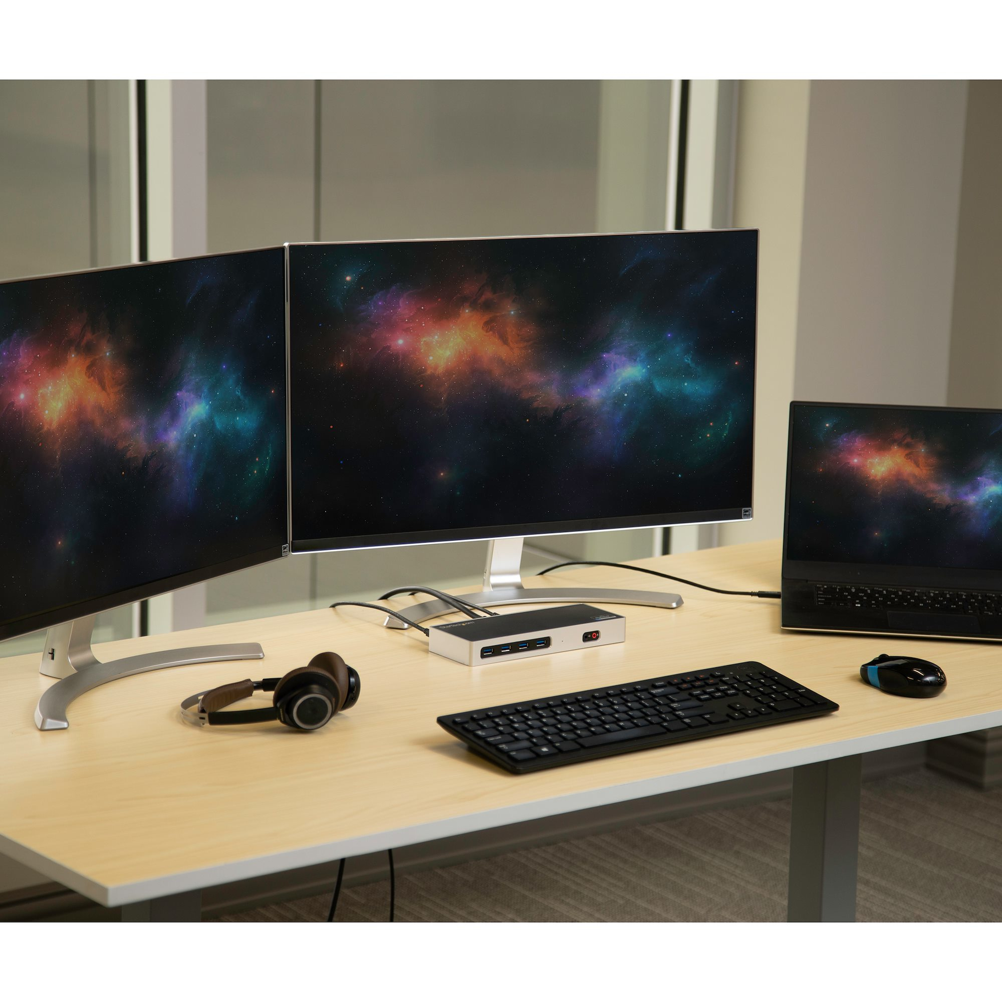 Escritorio de oficina con dos monitores, portátil, auriculares y ratón.