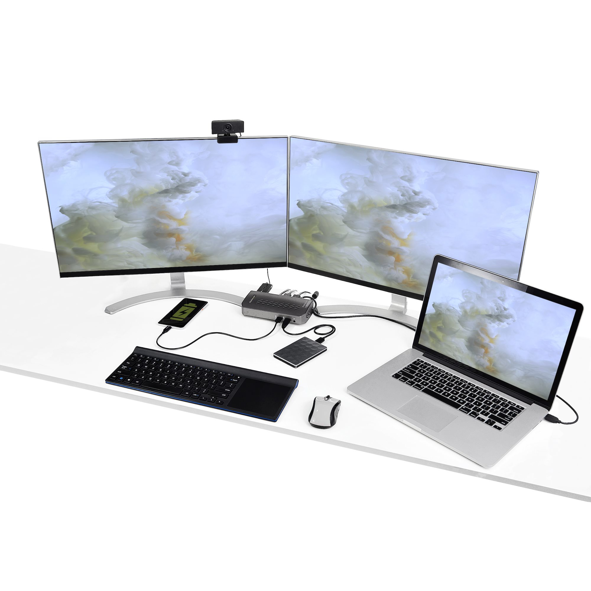 Configurazione scrivania con laptop, due monitor, tastiera, mouse e un hub StarTech. Scrivania bianca.