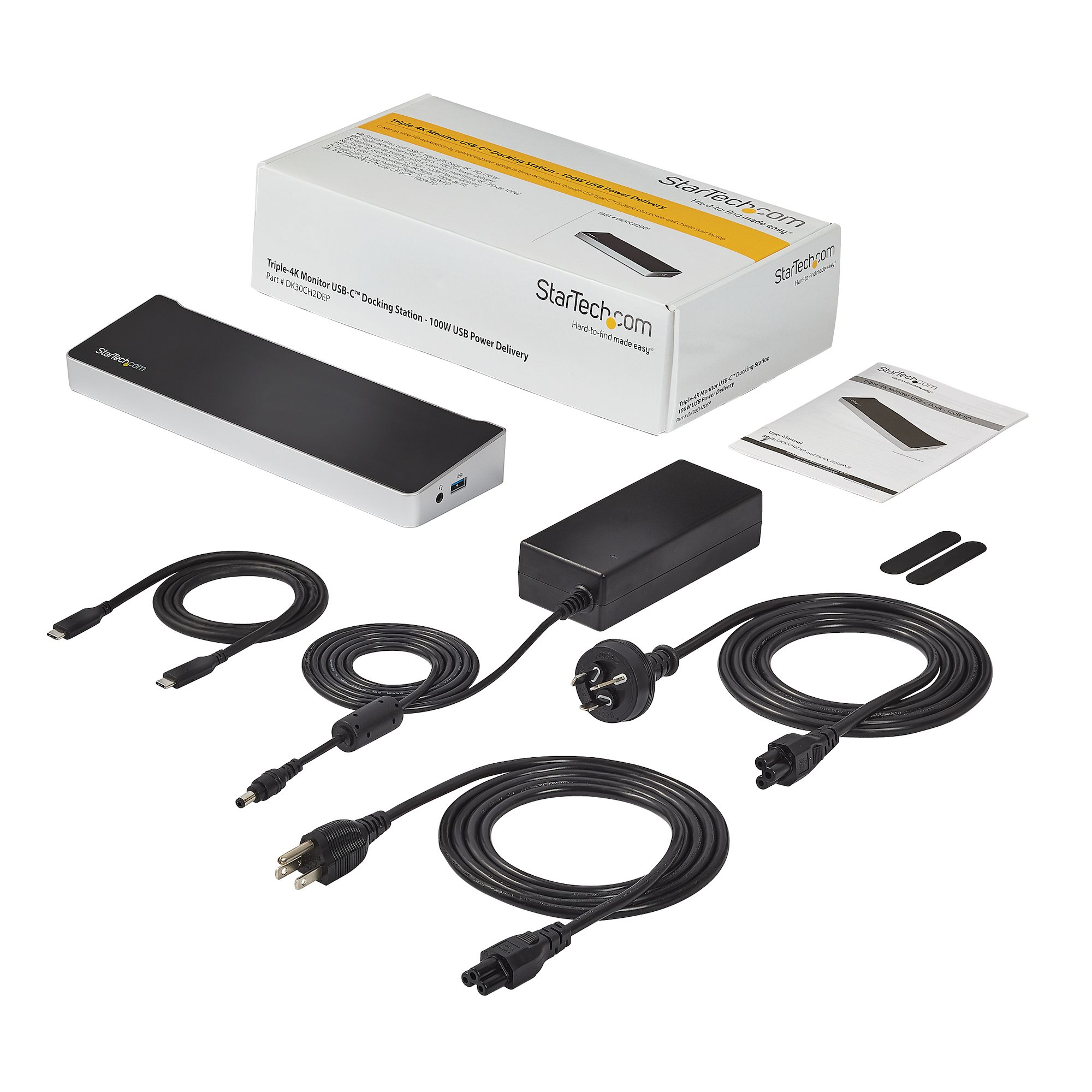 Kit de estación de acoplamiento con cables y adaptador de corriente. En caja, con diseño blanco y negro. Accesorios sobre superficie blanca.