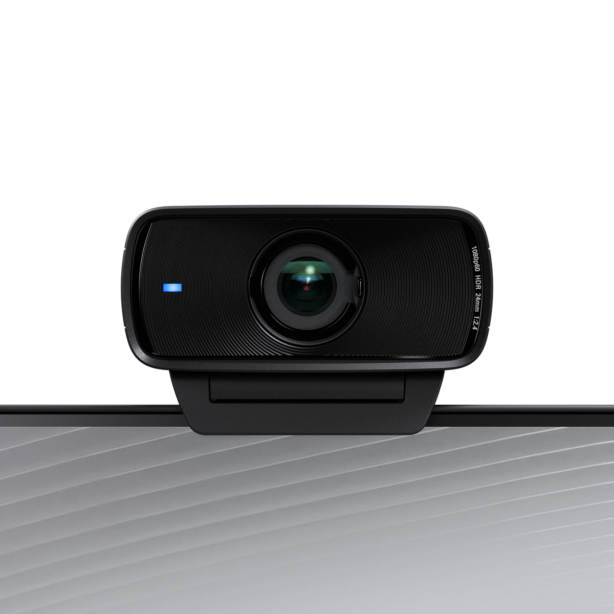 Webcam nera con una luce blu, su una superficie grigia, contro uno sfondo bianco.