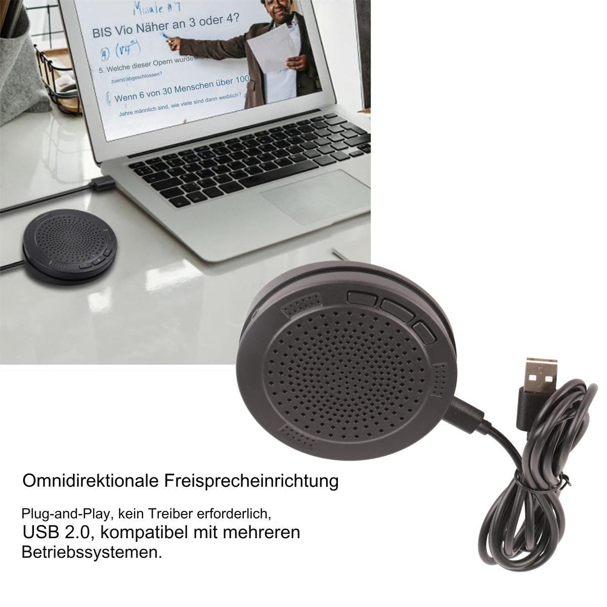 Schwarze Freisprecheinrichtung mit USB-Kabel neben einem Laptop auf einem Schreibtisch.