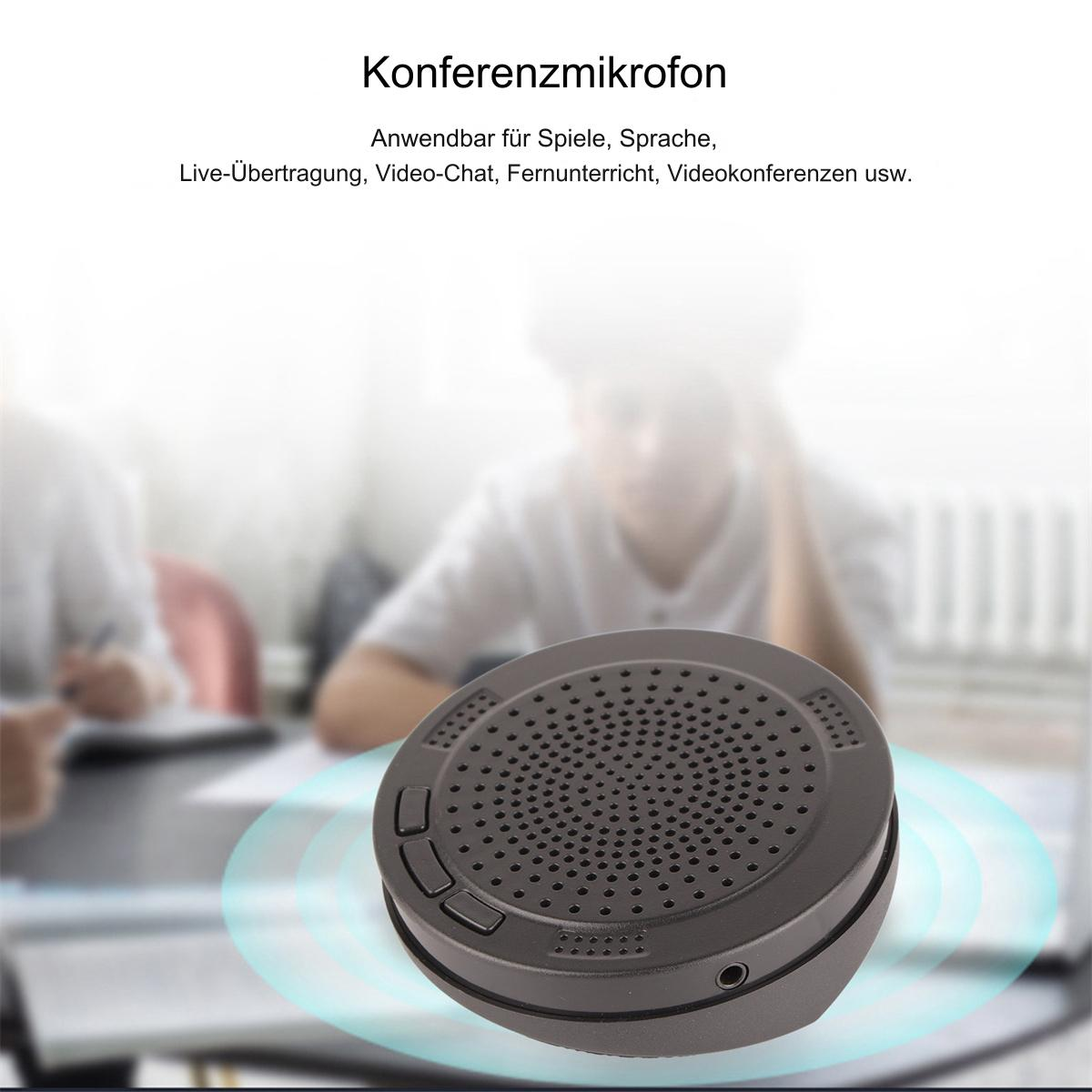 Schwarzes Konferenzmikrofon mit rundem Design. Es steht auf einem Tisch mit verschwommenem Hintergrund.