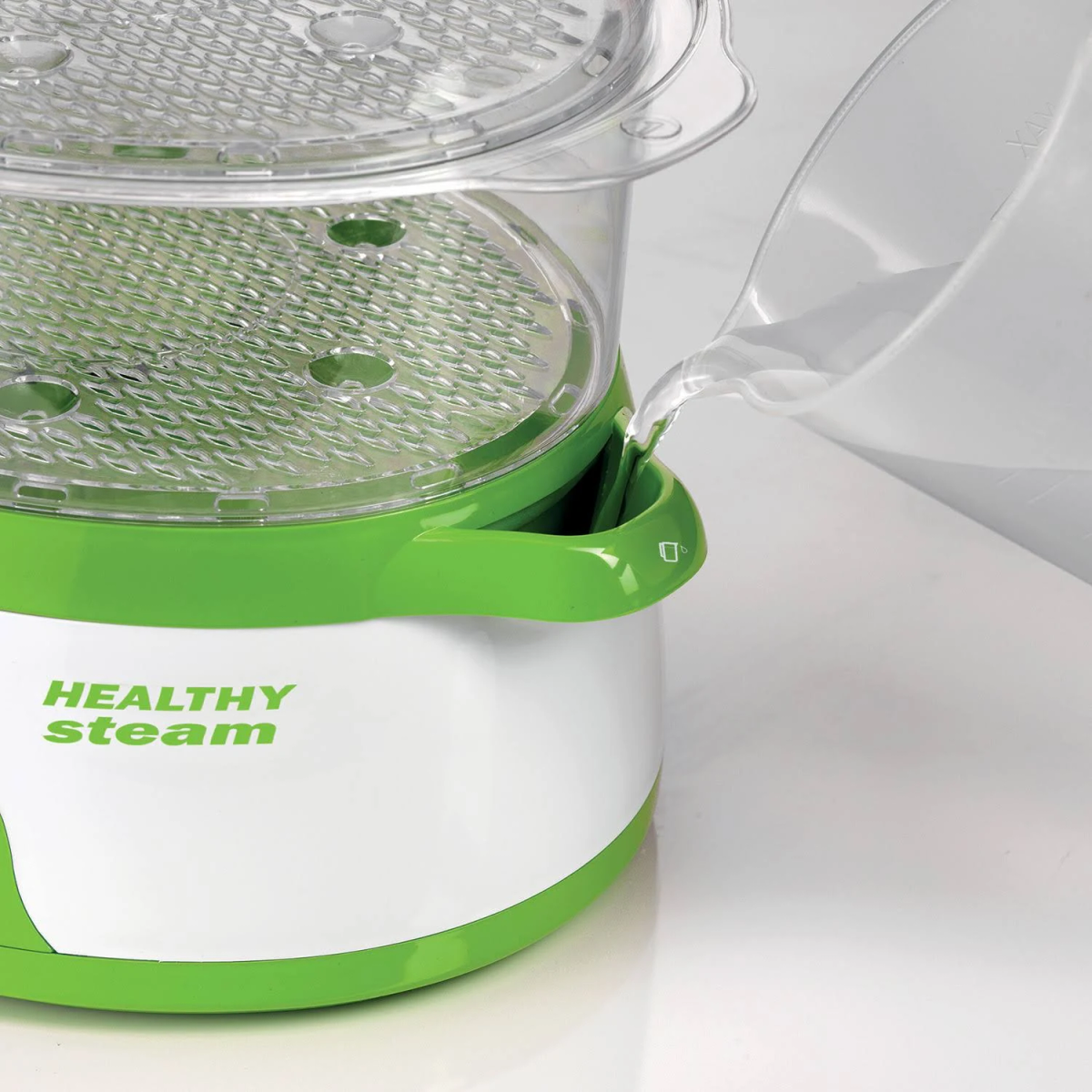 Un electrodoméstico Healthy Steam verde y blanco. Se vierte agua.