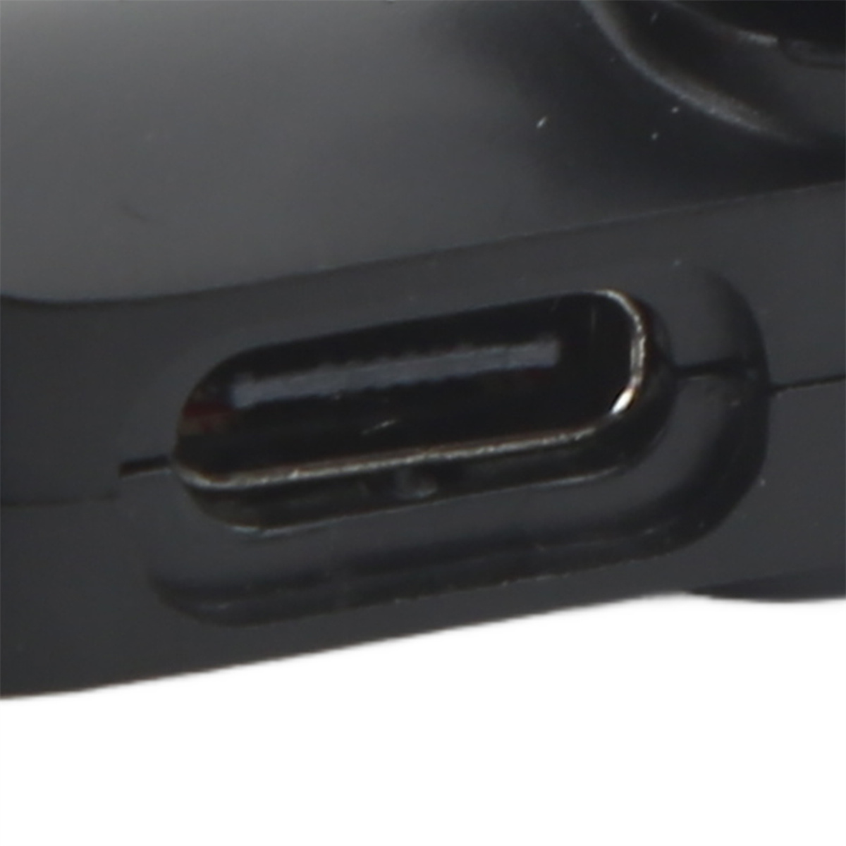 Nahaufnahme eines schwarzen USB-C-Anschlusses an einem schwarzen Gerät. Der Anschluss ist rechteckig und glänzend.