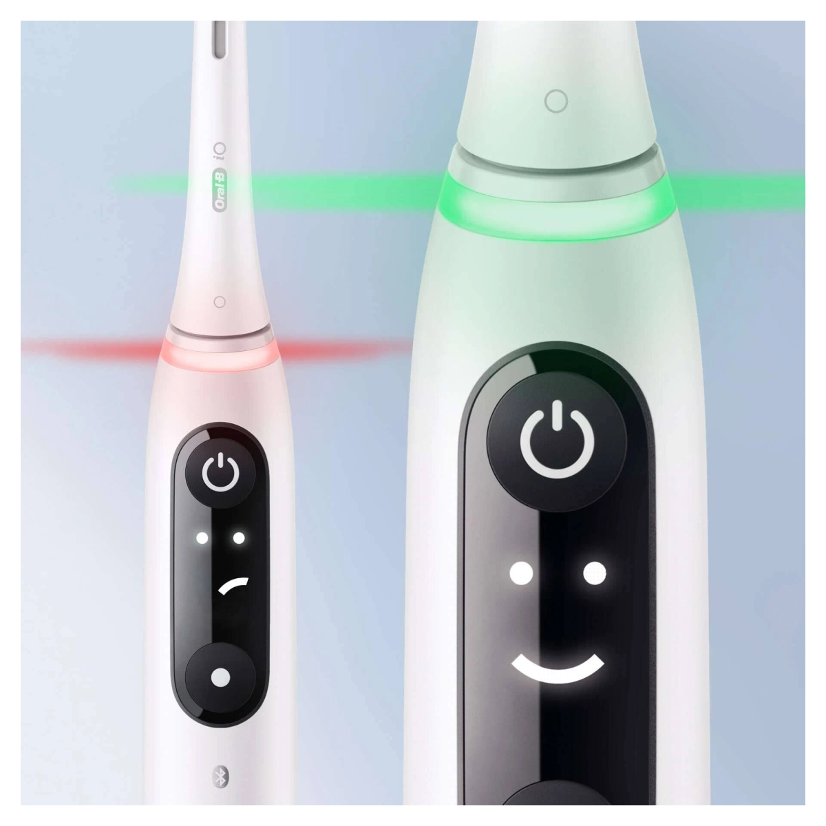 Dos cepillos de dientes eléctricos blancos con luces verdes y rojas.