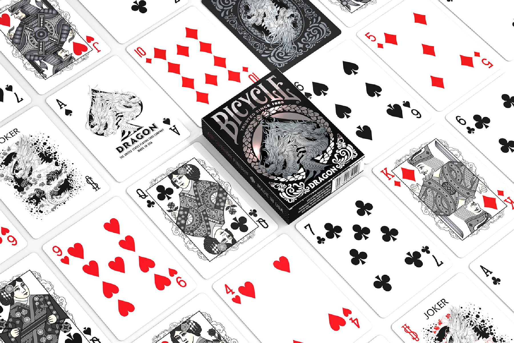 Spielkarten, Bicycle Dragon Deck. Karten verstreut um eine Schachtel. Pik, Herz, Karo und Kreuz sind sichtbar.
