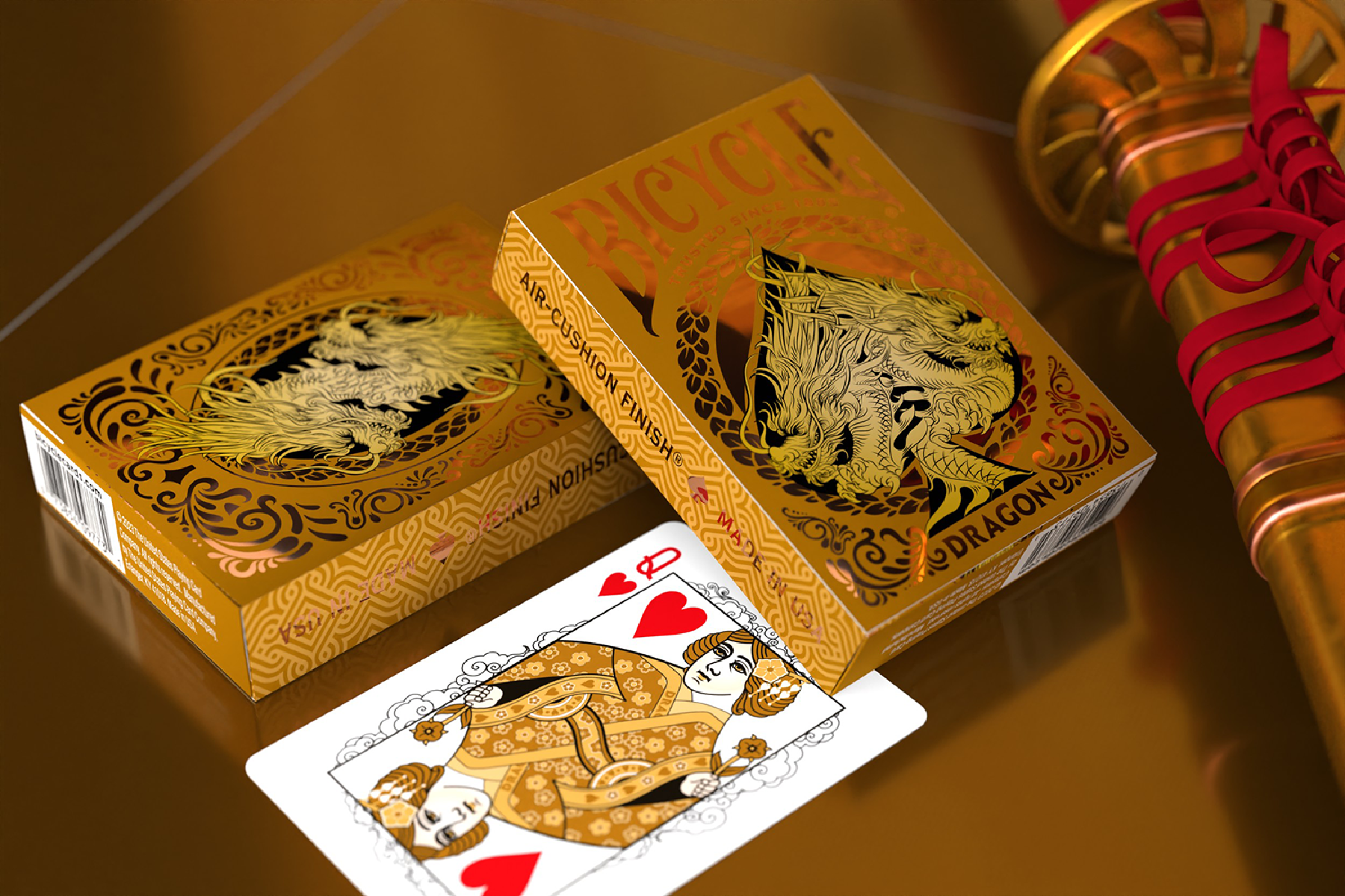 Zwei goldene Bicycle-Spielkartensets, eine Spielkarte und ein goldenes Katana mit rotem Griff.