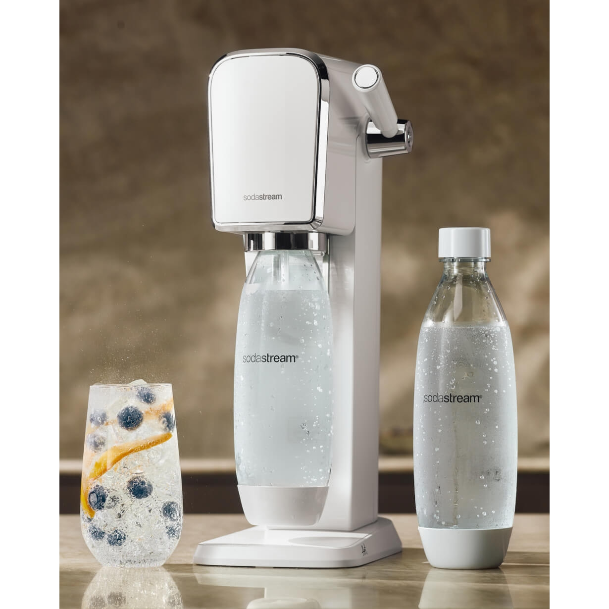 SodaStream-Maschine mit zwei Flaschen und einem Glas Soda mit Blaubeeren und Eis.