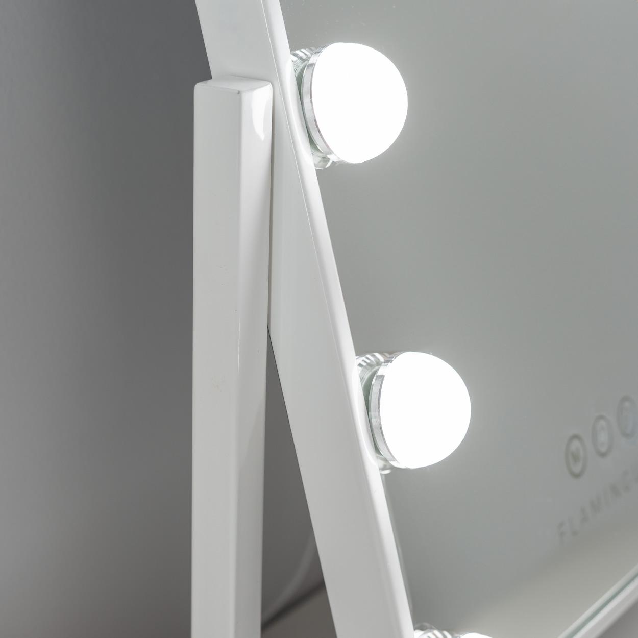 Un espejo de tocador blanco con tres luces LED brillantes. El marco es blanco.