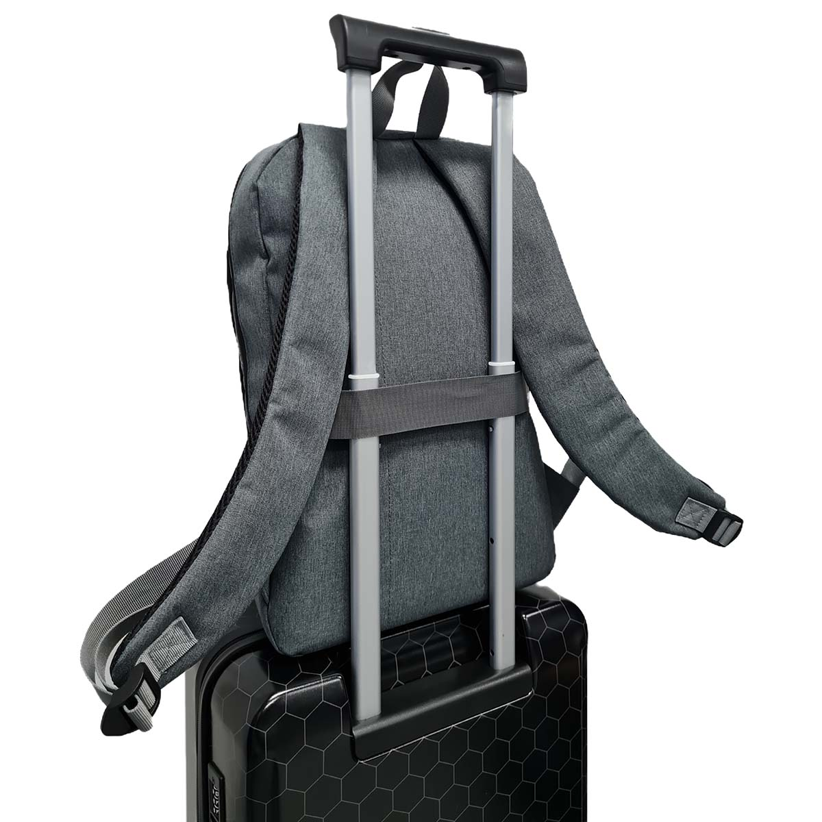 Ein grauer Rucksack auf einem schwarzen Koffer. Der Rucksack ist am Griff des Koffers befestigt.