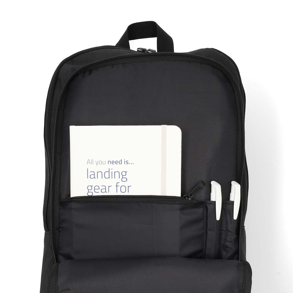 Schwarzer Rucksack mit Notizbuch und Stiften in den Taschen. Text auf dem Notizbuch: landing gear for...