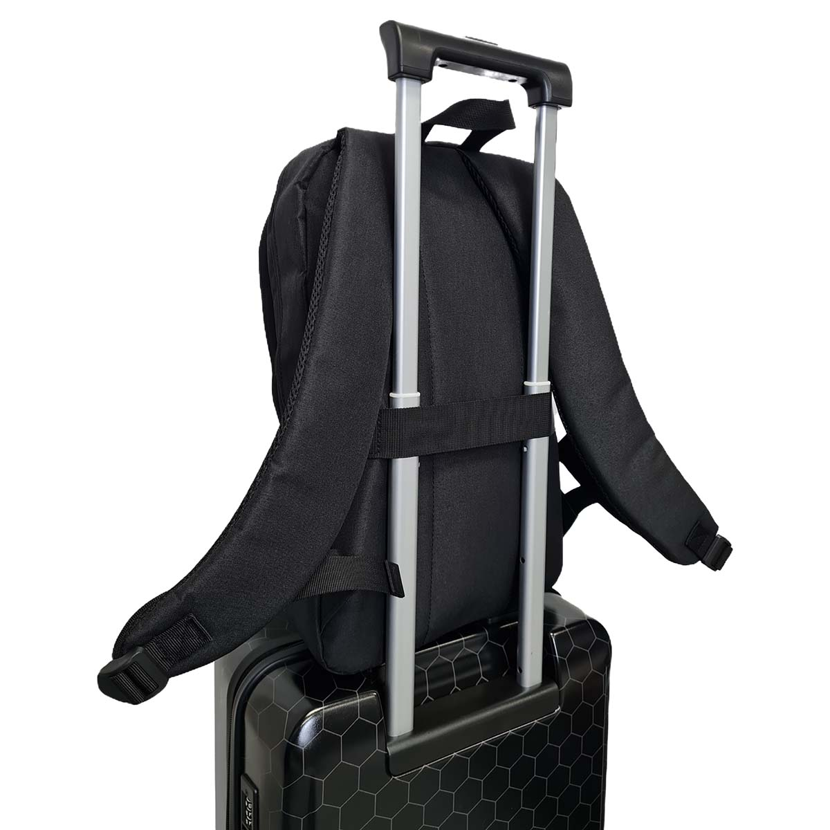 Ein schwarzer Rucksack auf einem schwarzen Koffer mit silbernem Griff.