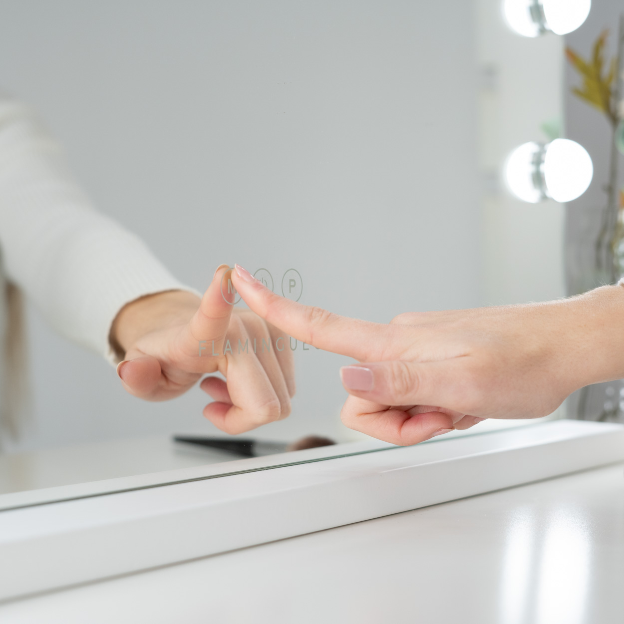 Mano tocando un espejo, con reflejo de la misma mano.