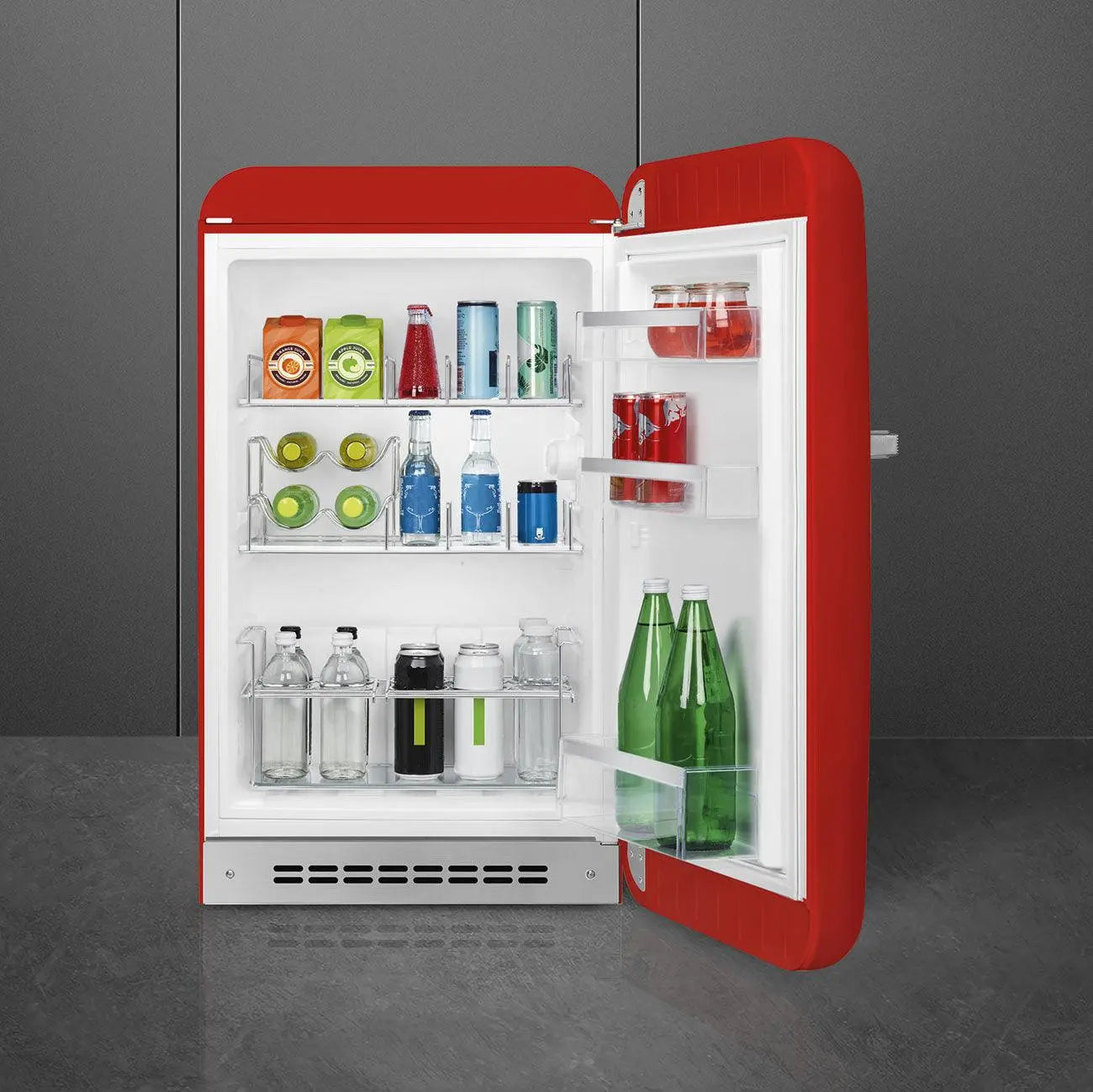 Refrigerador retro rojo, puerta abierta, lleno de botellas, frascos y latas, sobre fondo gris.