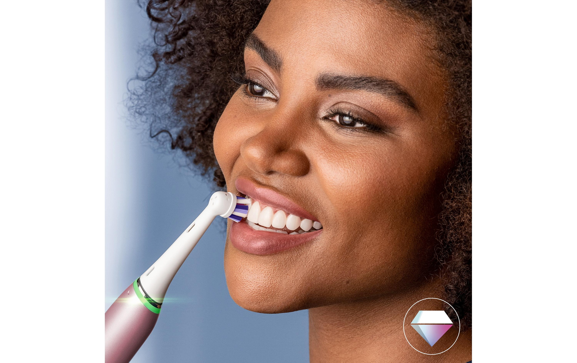Kobieta szczotkująca zęby szczoteczką elektryczną. Zbliżenie pokazuje białe zęby i różowe dziąsła.