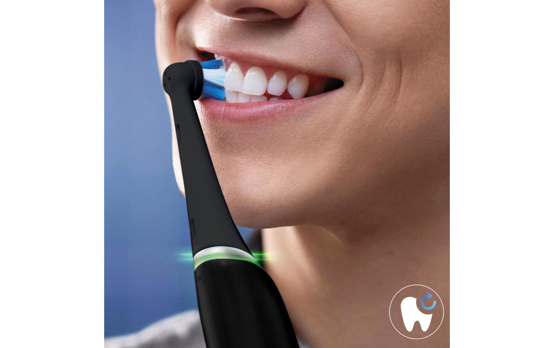 Una persona cepillándose los dientes con un cepillo de dientes eléctrico negro. El cepillo es azul.