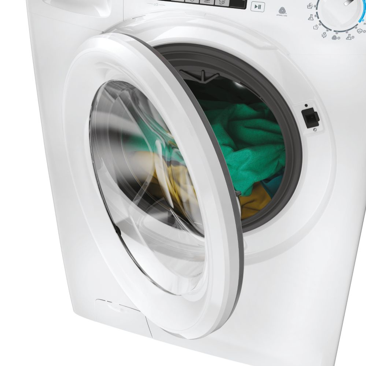 Una lavadora blanca con la puerta abierta, revelando ropa verde y amarilla en el interior.