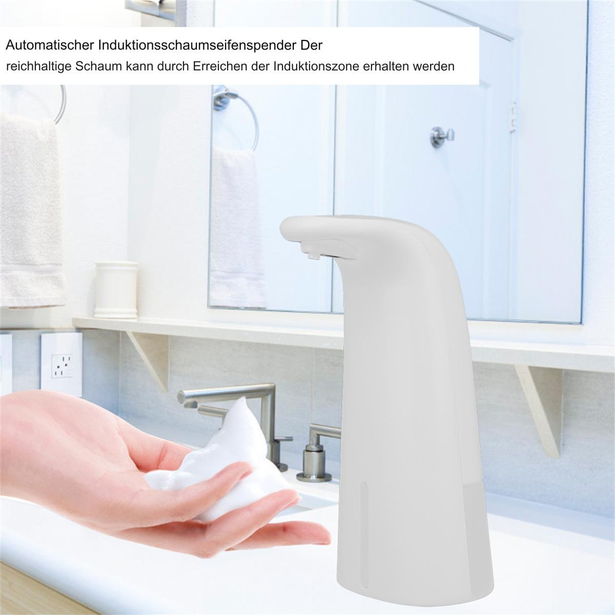 Weißer automatischer Seifenspender gibt Schaum auf eine Hand, in einem Badezimmer.