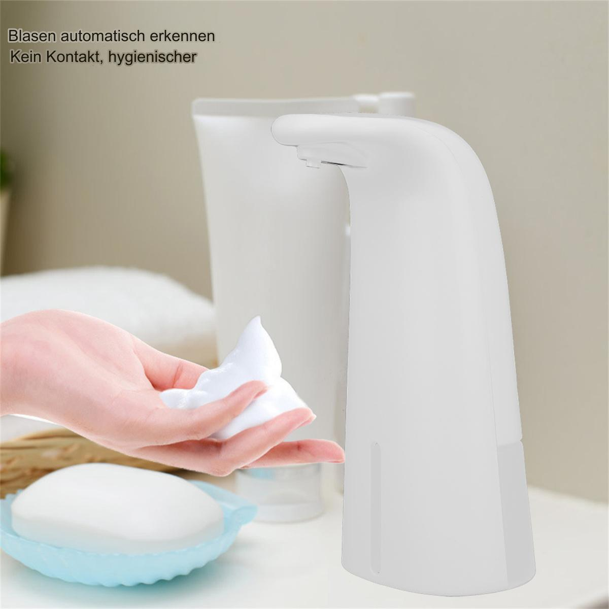 Weißer automatischer Seifenspender. Eine Hand empfängt Schaumseife. Eine Seife im Hintergrund.