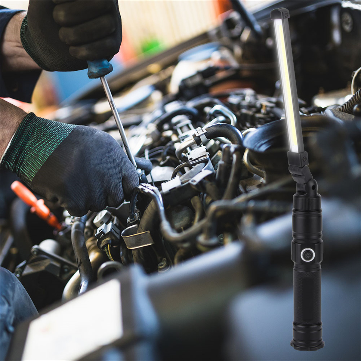 Ein Mechaniker benutzt einen Schraubendreher in einem Motorraum, mit einer Arbeitsleuchte im Vordergrund.