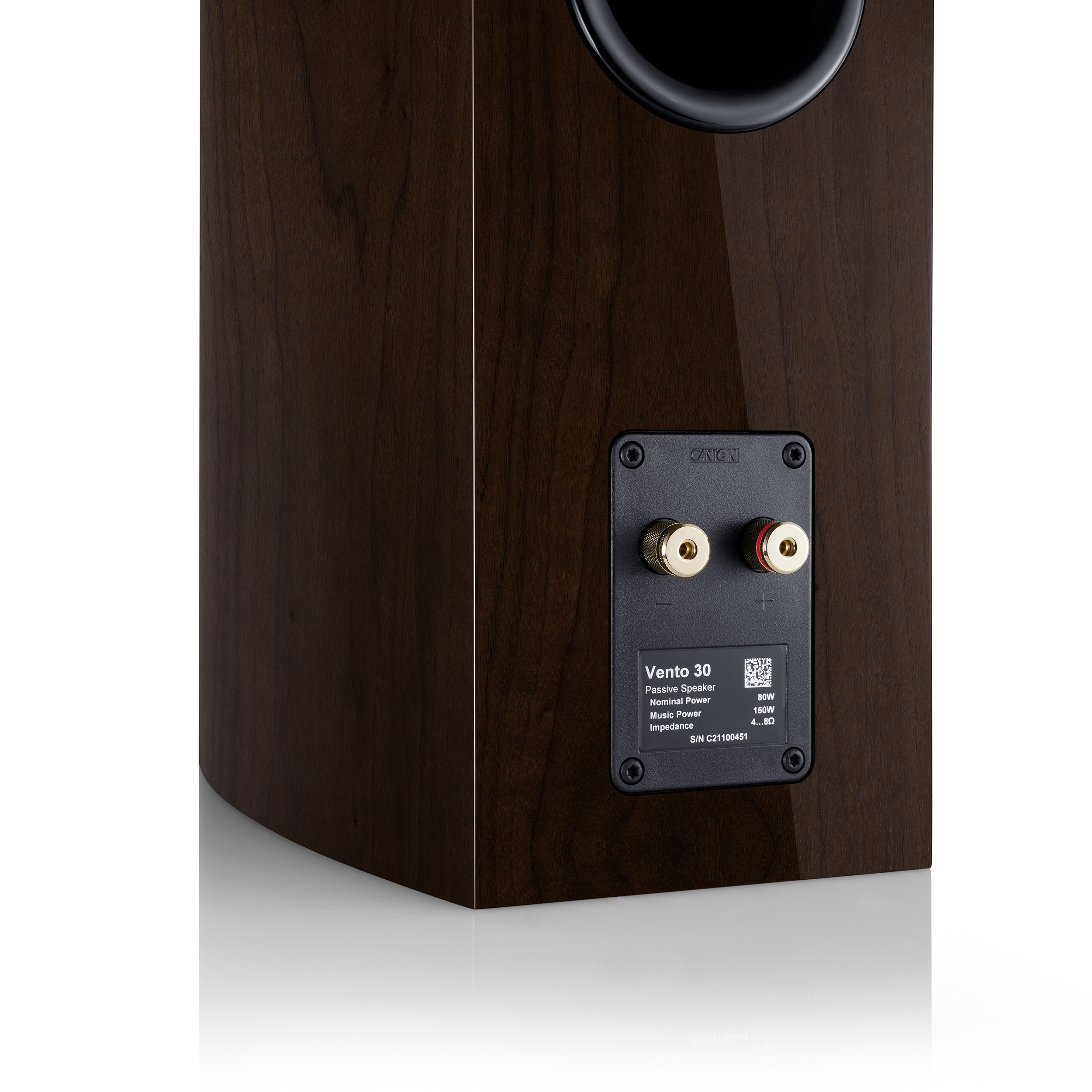 Achterkant van een houten luidspreker met gouden connectoren en een productlabel.