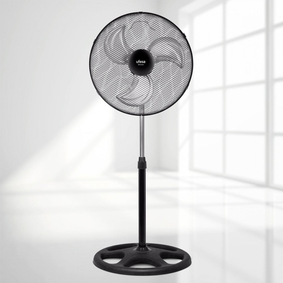 Czarny i srebrny wentylator stojący Ufesa w jasnym, nowoczesnym otoczeniu pokoju.
