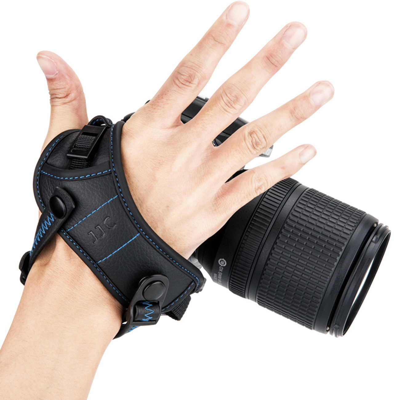 Eine Hand, die eine Kamera mit einem schwarzen und blauen Kameragurt hält, weißer Hintergrund.