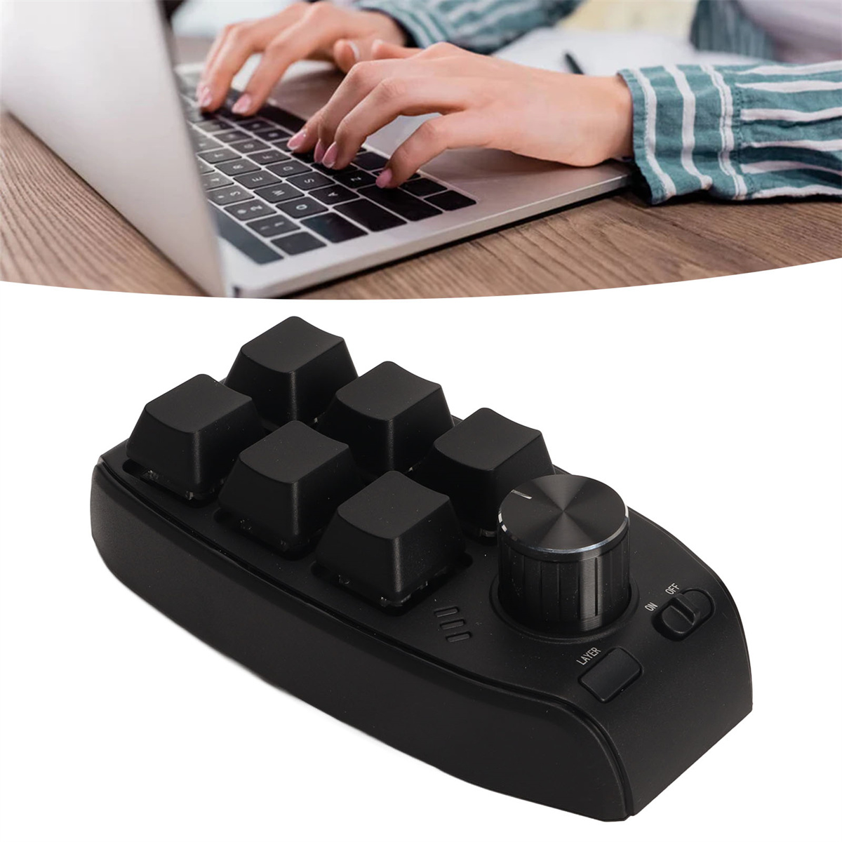 Hände einer Person, die einen Laptop und eine schwarze Bearbeitungskonsole mit Knöpfen und einem Drehregler benutzen.