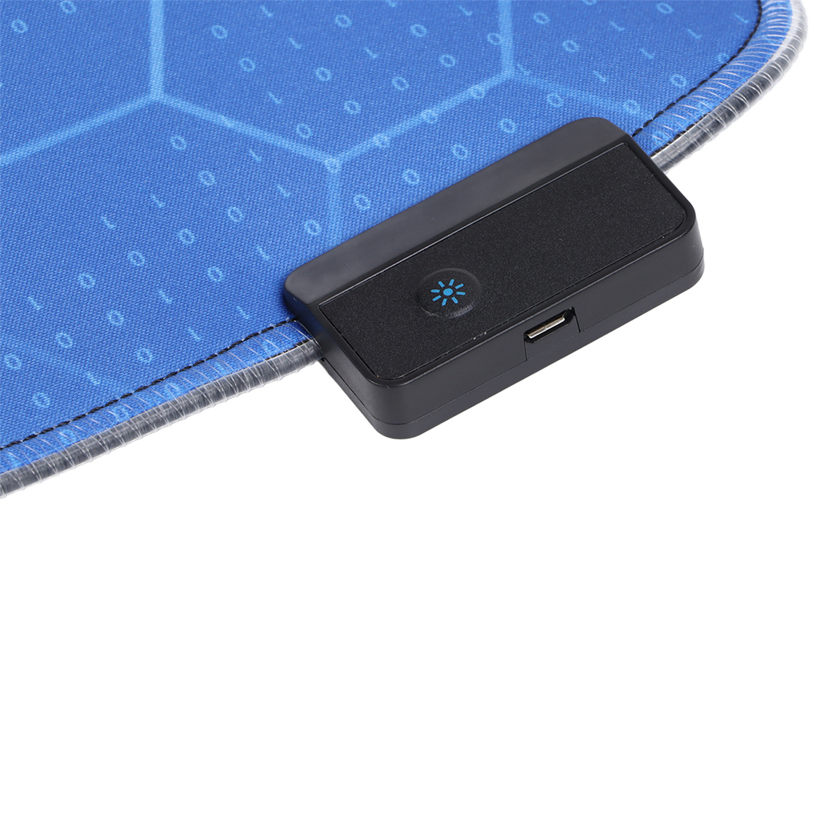 Ein schwarzes Gerät mit USB-Anschluss liegt auf einem blauen Mauspad mit weißen Linien und Zahlen. Das Gerät hat ein blaues Licht.