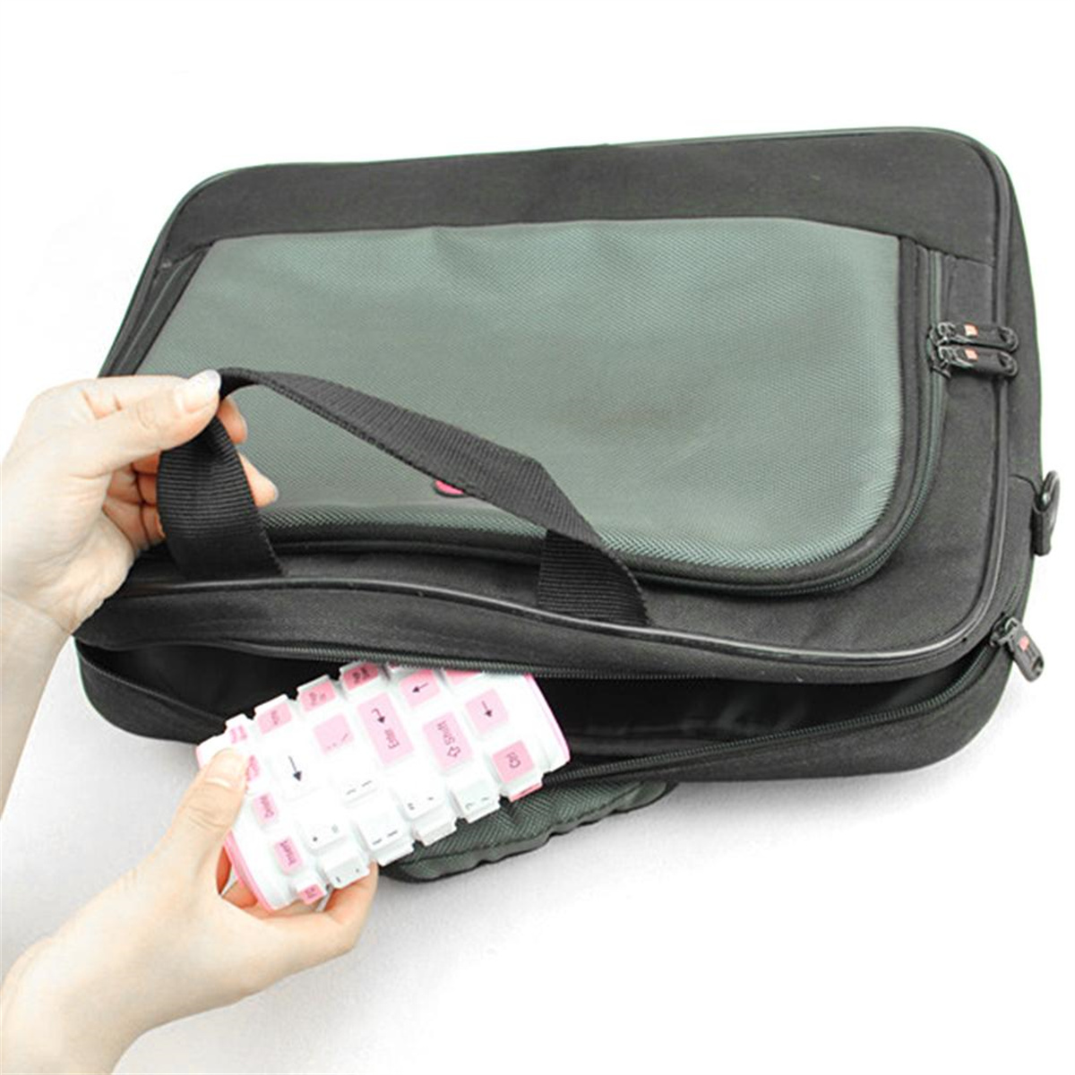 Hände einer Person, die eine Tastatur halten. Die Tastatur ist weiß mit rosa Tasten. Schwarze Tasche mit Reißverschluss.