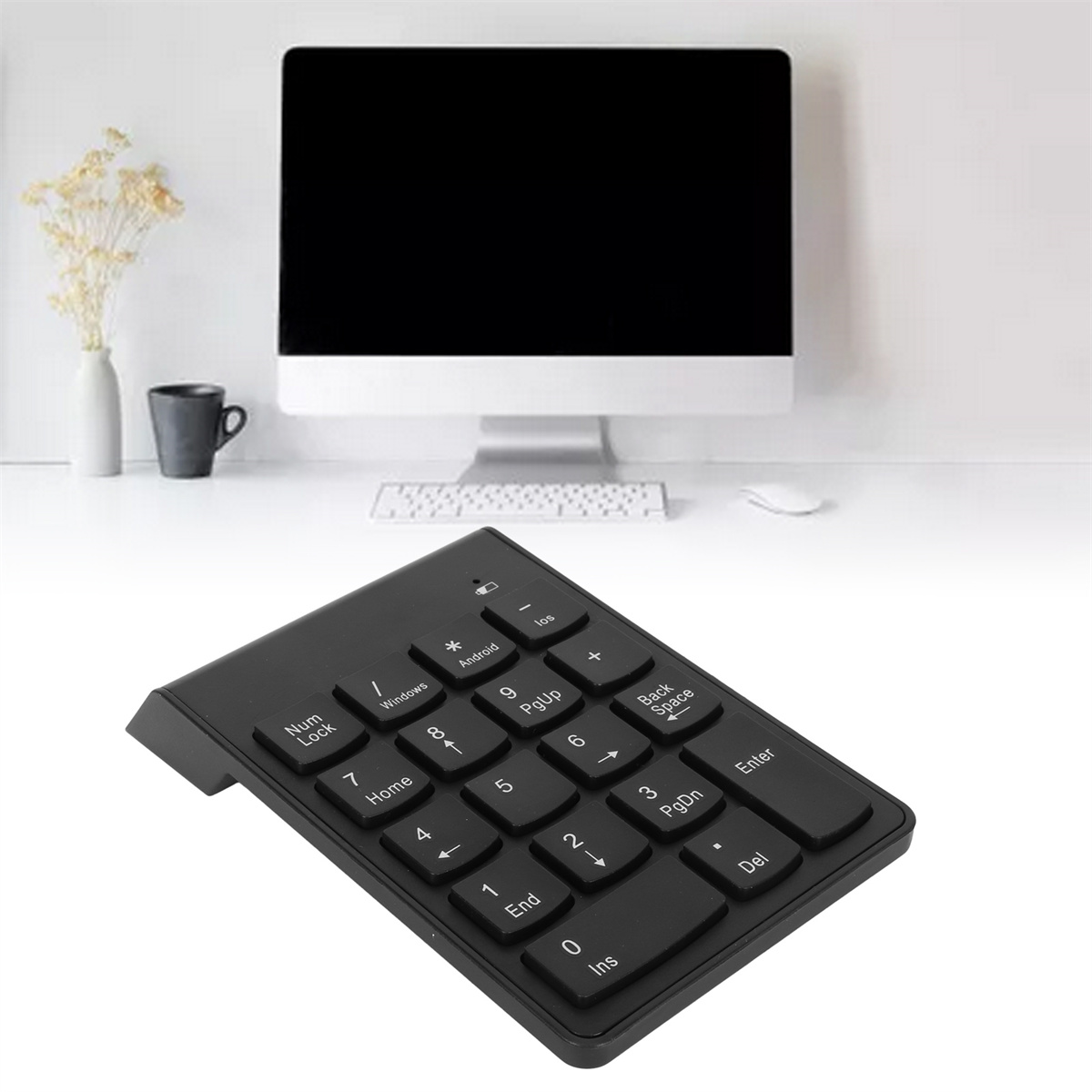 Ein schwarzer Nummernblock vor einem Computer. Die Tastatur hat verschiedene Tasten.