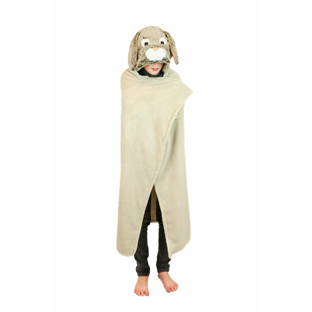 Ein Kind trägt eine braune Hundekapuze und eine beige Decke. Barfuß auf weißem Hintergrund.