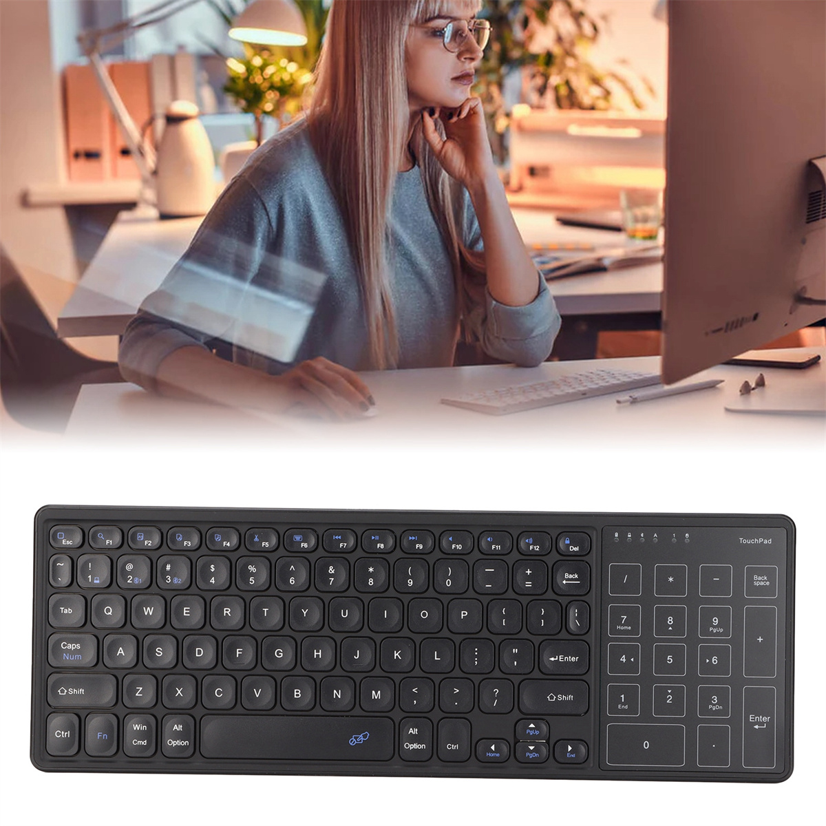 Eine schwarze Tastatur neben einer Frau, die einen Computer benutzt. Die Tastatur hat ein Touchpad.