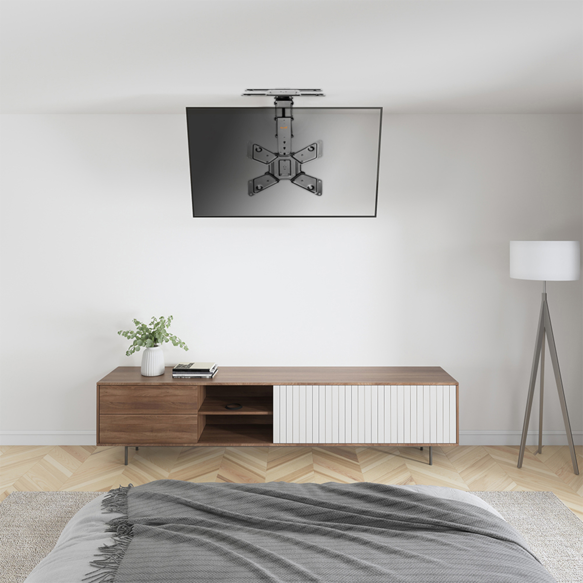 Ein Fernseher an einer Deckenhalterung, mit einer Medienkonsole und einem Bett im Raum.