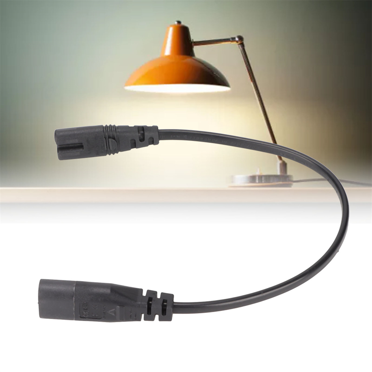 Schwarzes Netzkabel mit einer Schreibtischlampe im Hintergrund.