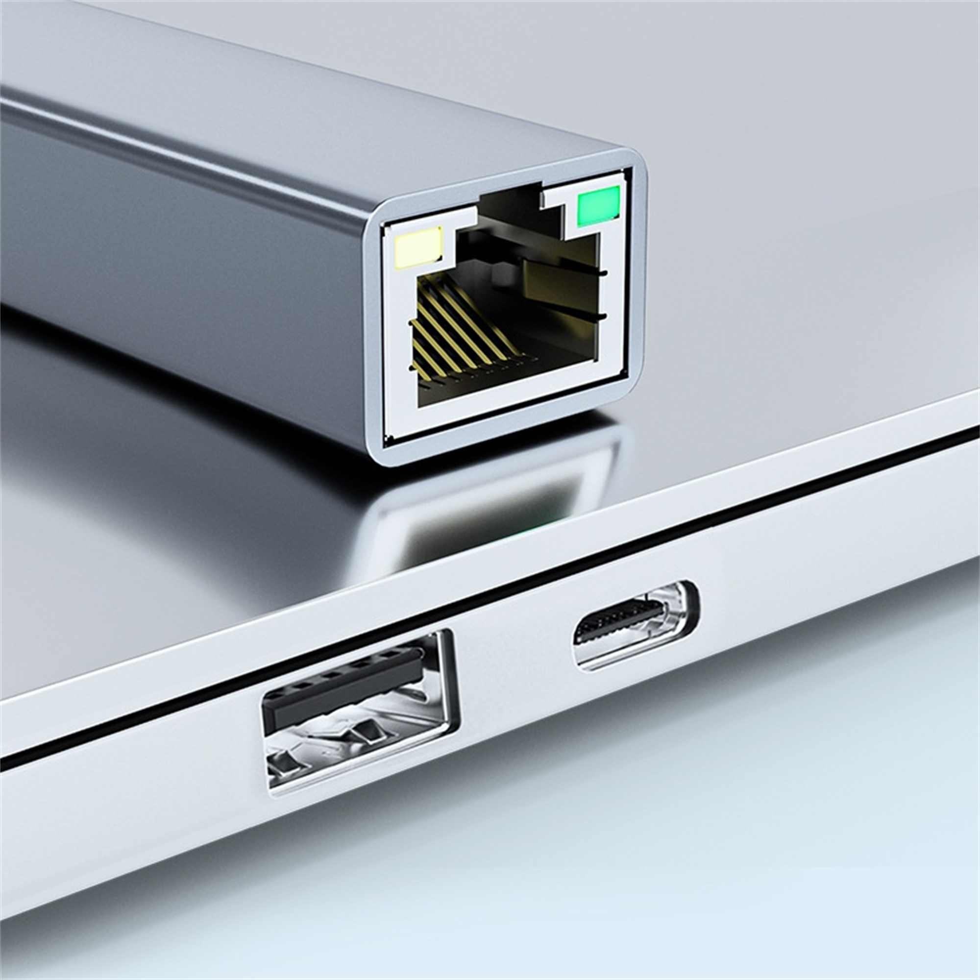 Grauer Netzwerkadapter an einen Laptop angeschlossen. Er hat einen Ethernet- und einen USB-Anschluss.
