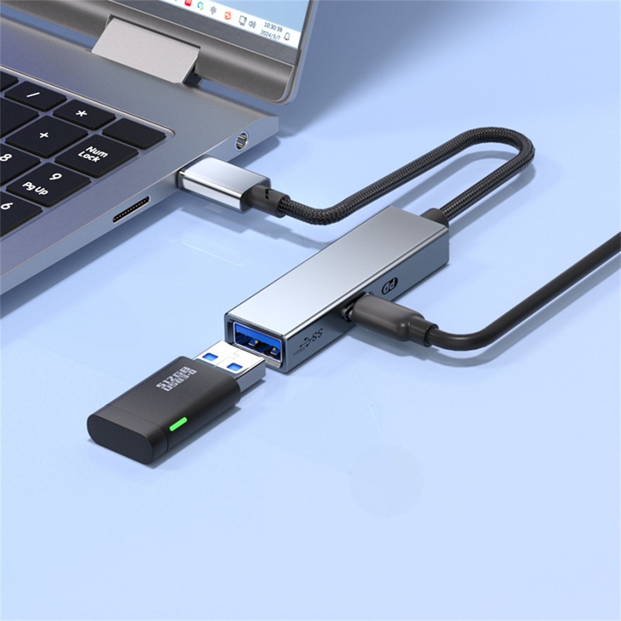 Ein silberner USB-Hub, der mit einem Laptop verbunden ist, mit einem eingesteckten USB-Laufwerk. Blauer Hintergrund.