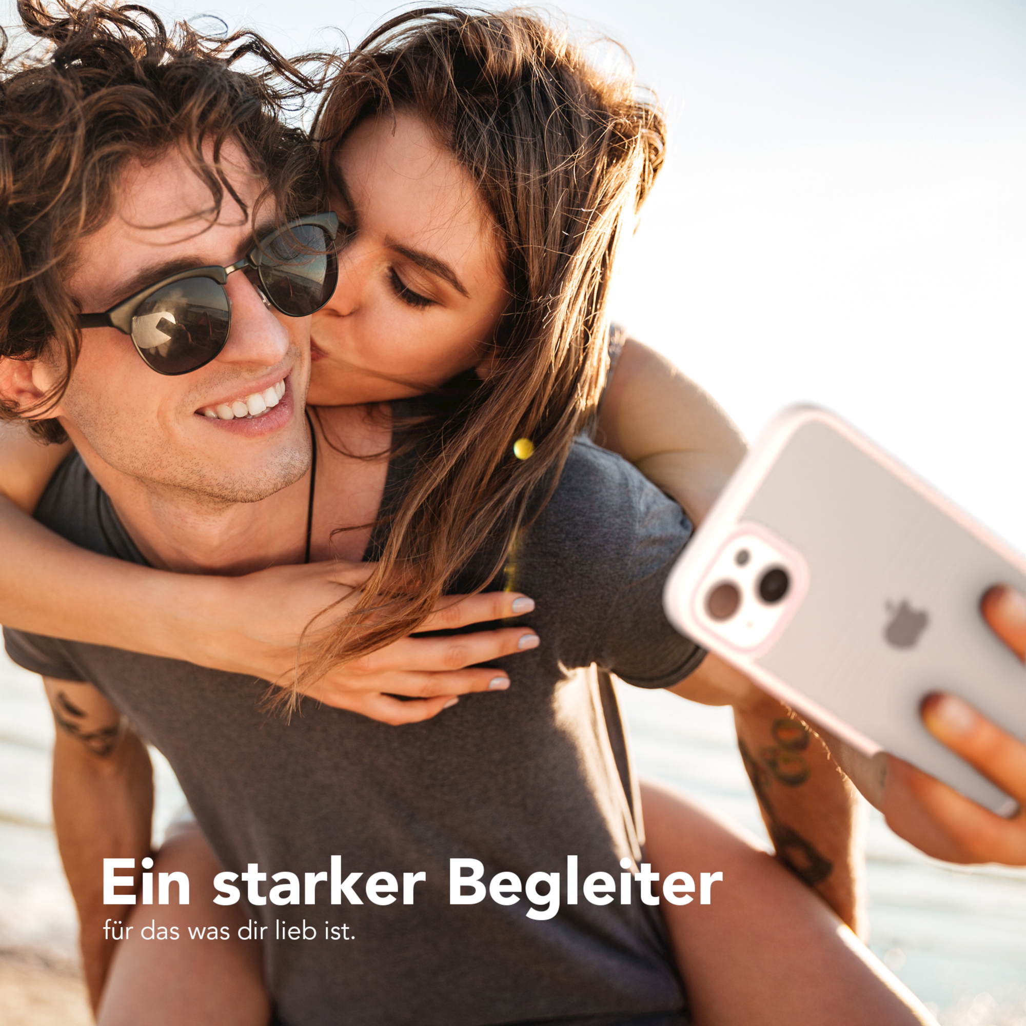 Paar macht Selfie, Frau küsst Mann auf die Wange. Text: Ein starker Begleiter.