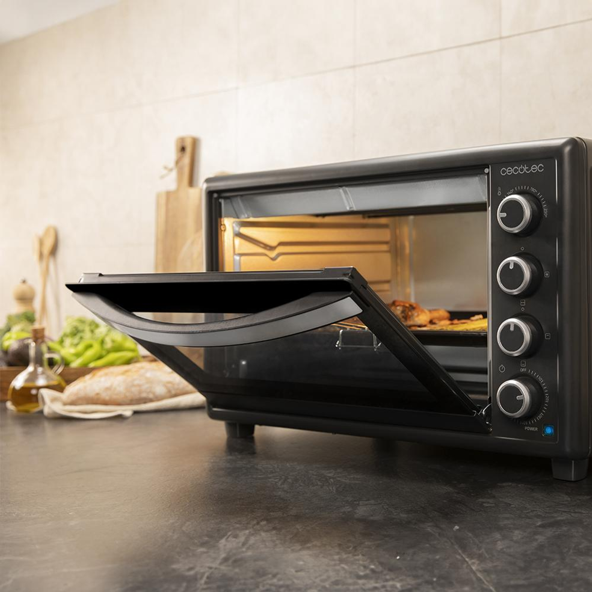 Forno nero con porta aperta, che mostra teglia con cibo. Ambiente cucina, toni neutri.